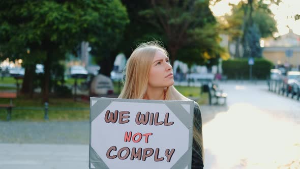 Protest Walk: Woman Holding Placard with Words That People Won't Comply