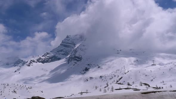 Landscape View of Alpine Mountain Snowy Peak in the Clouds. Simplon Pass.