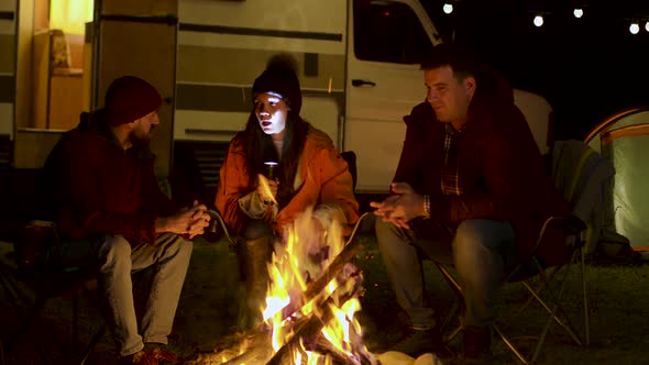 Girl Telling a Scary Story To Her Friends Around Camp Fire