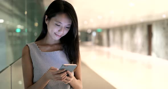 Woman using cellphone and walking in the city 