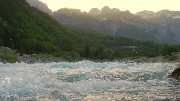 Rapid Mountain River Water with Majestic Rocky Mountains at Background