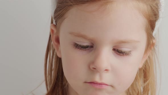 Funny little girl looking at camera at home