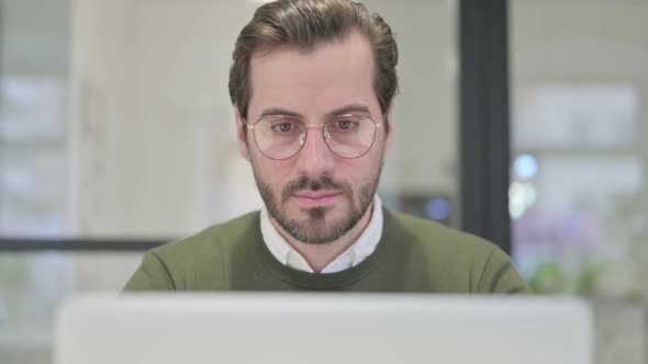 Close Up of Young Businessman Working on Laptop