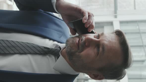 Vertical Shot of Business Man Talking on Phone in Lift