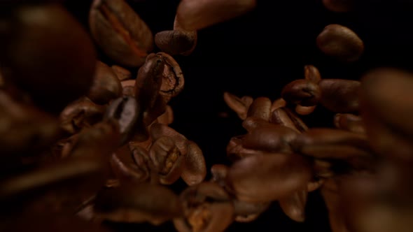 Super Slow Motion Detail Shot of Coffee Beans Falling Down on Black Background at 1000Fps