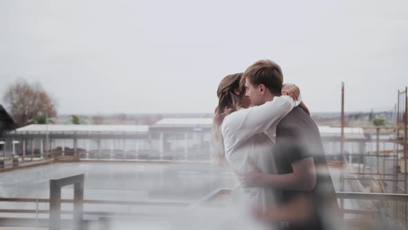 Attractive Couple in Love Hugs Medium Shot of the Couple Hugging and Kissing on the Balcony Slow