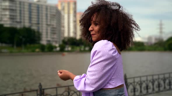 Young Cheerful Black Woman Is Walking in City Embankment and Dancing, Happy Townswoman