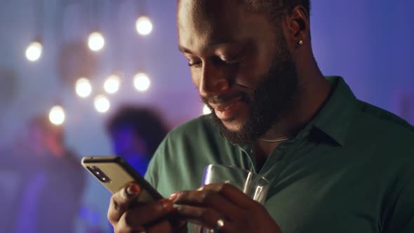 Black Man Using Smartphone During Home Party