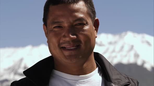 Slow motion close-up shot of a smiling middle-aged Asian man