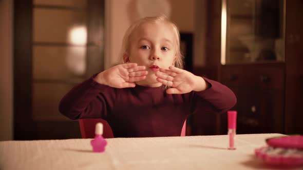 Cute Little Baby Playing Manicure Cosmetics and Blows on His Nails