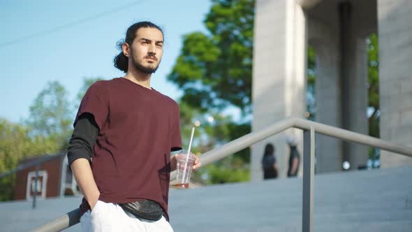 Closeup Portrait of Handsome Arab Man Sitting in the Park and Drinking Coffee Tonic