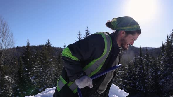 Manually Removing Fresh Snow in a Sunny Winter Day