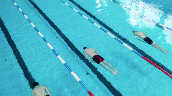 Three Athletes Swim Under Water