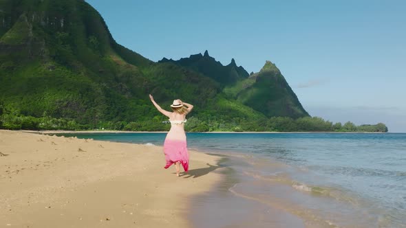 Slow Motion Young Woman in Colorful Dress Running By Beach to Mountain Peaks