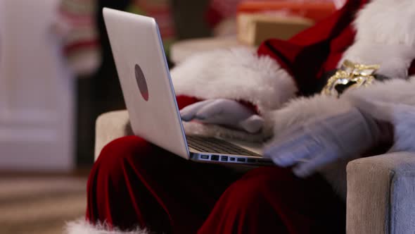 Santa Claus using laptop, closeup alt