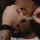 Man Shaving Beard of African American Man with Straight Razor in Barbershop - VideoHive Item for Sale