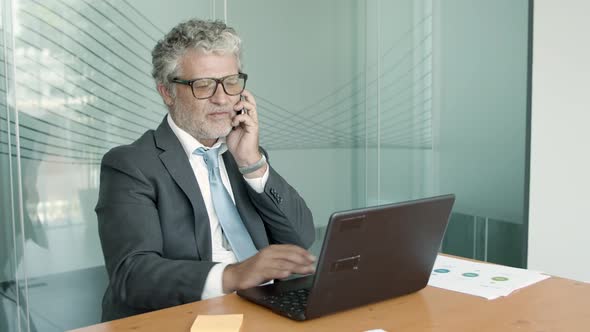 Positive Mature Executive Wearing Suit and Glasses