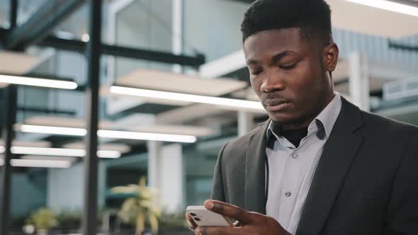 Thoughtful African Man Professional Broker Using Mobile Apps for Online Sales Chatting with Friend