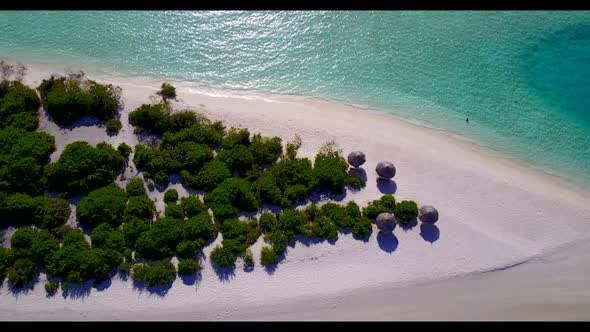 Aerial drone shot abstract of tranquil coastline beach trip by blue green sea with clean sandy backg