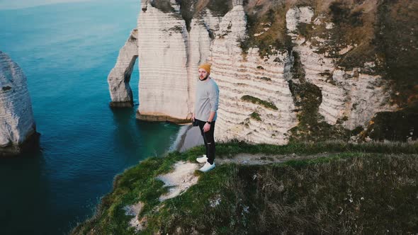 Drone Flying Around Young Happy Excited Businessman Watching Epic Ocean View on Top of Normandy