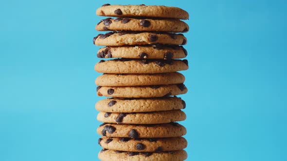 A stack chocolate chip cookies rotate on a blue background. American cookies close up.