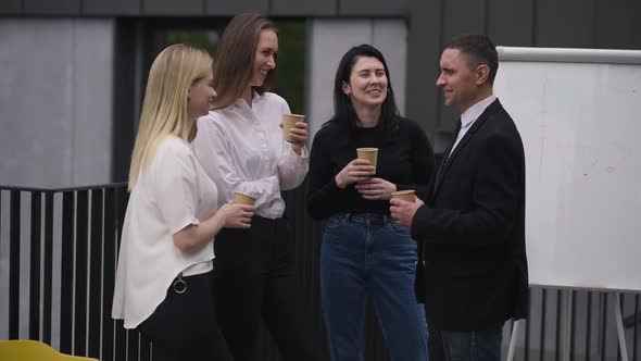 Positive Business People Talking Drinking Coffee Standing Outdoors on Break