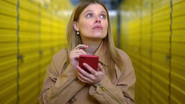 Hesitating Brunette Young Woman with Green Eyes Using Smartphone Looking Around Searching Self