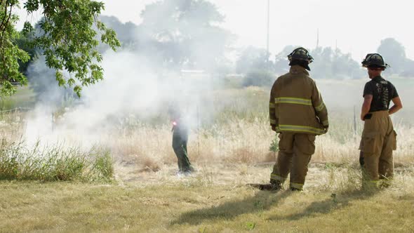 Firemen near field on fire