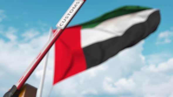 Closing Boom Barrier with CUSTOMS Sign Against the UAE Flag