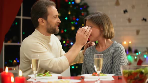 Mid-Aged Man Tenderly Kissing Wife on Christmas Eve