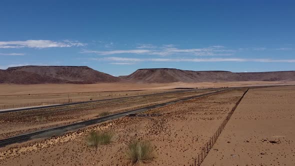 Aerial footage of the railroad and a highway in the middle of Namib desert