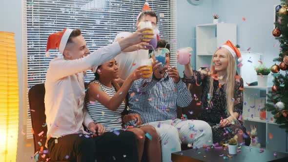 Close Up of Cheerful Company Celebrating Christmas in Confetti Blowing