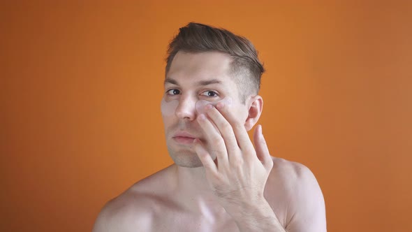 Caucasian Man Using a Transparent Patches for Wrinkles Under the Eyes, Nourishes the Skin of the