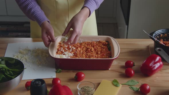 Woman Is Putting Cheese Layer On Appetizing Meal