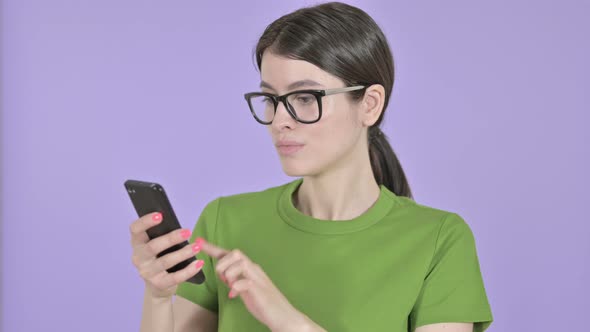 Young Woman Using Smartphone on  Pink Background