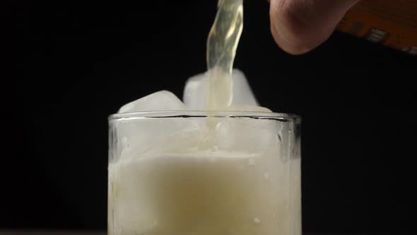 Pouring Orange Drink. Slow Motion. Carbonated orange drink is poured into a glass. Pouring orange ju