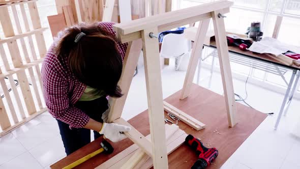 Stylish craftswoman working in carpentry. Woodwork and furniture making concept.
