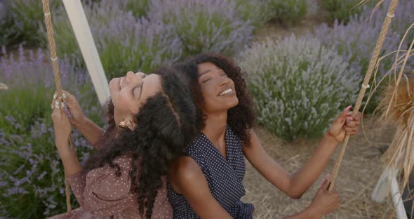 Female Diverse Friends on a Swing in Lavender Field
