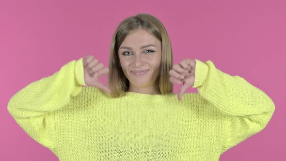 Beautiful Young Girl Showing Thumbs Down, Pink Background