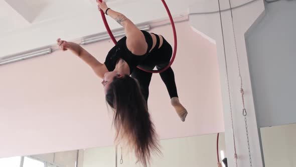 A Young Woman Gymnast Upside Down in an Acrobatic Ring