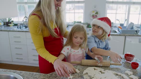 Siblings making christmas cookies at home