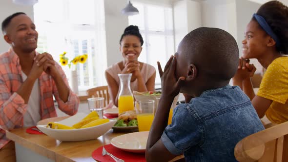 Front view of happy black family having food at dining table in a comfortable home 4k