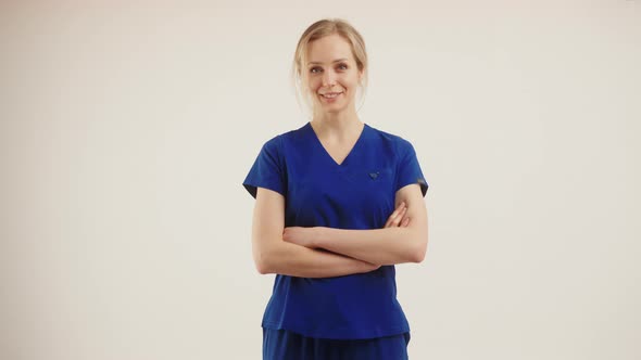 Medium Studio Shot Over White Grey Background of a Beautiful Female Nurse in Dark Blue Uniform