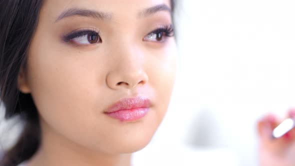 Professional Makeup Artist Working Creating Fashionable Makeup for Beautiful Asian Model Closeup