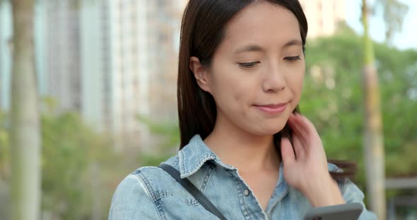 Young Woman reading on smart phone at outdoor park