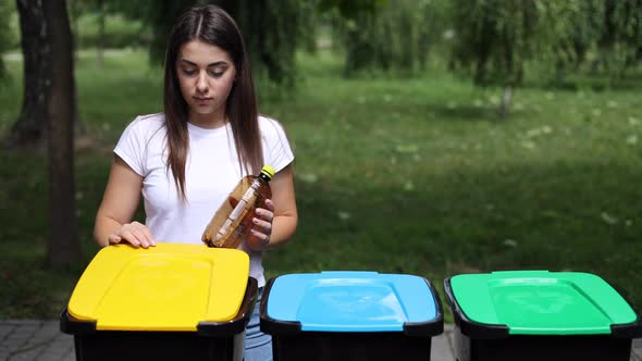 Woman Throwing Empty Plastic Water Bottle in Recycling Bin