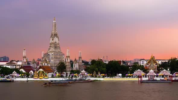 day to night time lapse of Wat Arun Temple with Chao Phraya river in Bangkok, Thailand