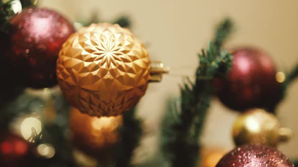 Close Up of Red Ball Toy Decorations on Christmas Tree with Blurred with Glitter Overlay Copy Space