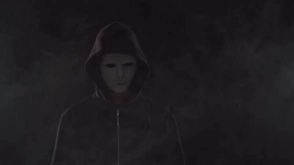 Portrait of computer hacker in hoodie. Obscured dark face.