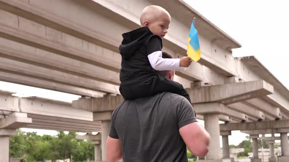 Young Ukrainian Businessman and His Child Waving the National Bicolor Flag 